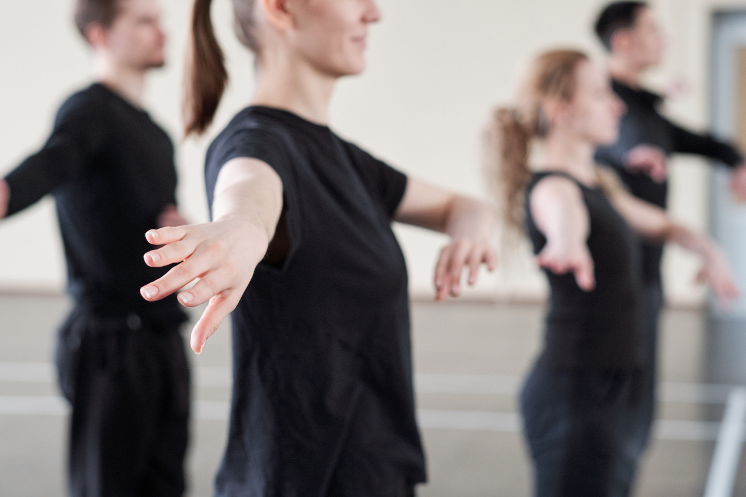 Fyra svartklädda personer tränar koreografi inför dansuppvisning